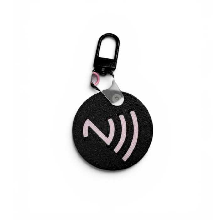 Zadná strana okrúhlej NFC kľúčenky s ružovým symbolom bezkontaktného snímania pre smartfóny.